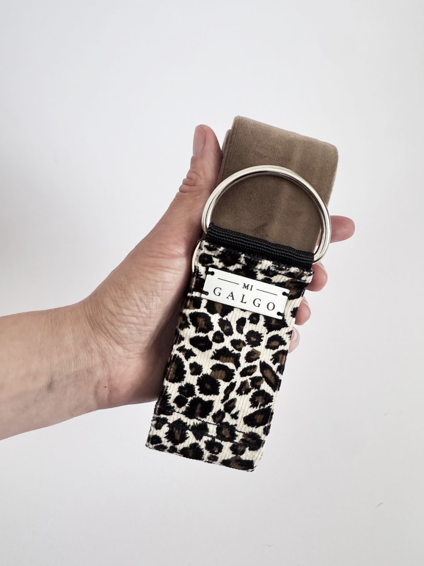 Peggy collar held in hand showing sand velour and leopard velvet detail